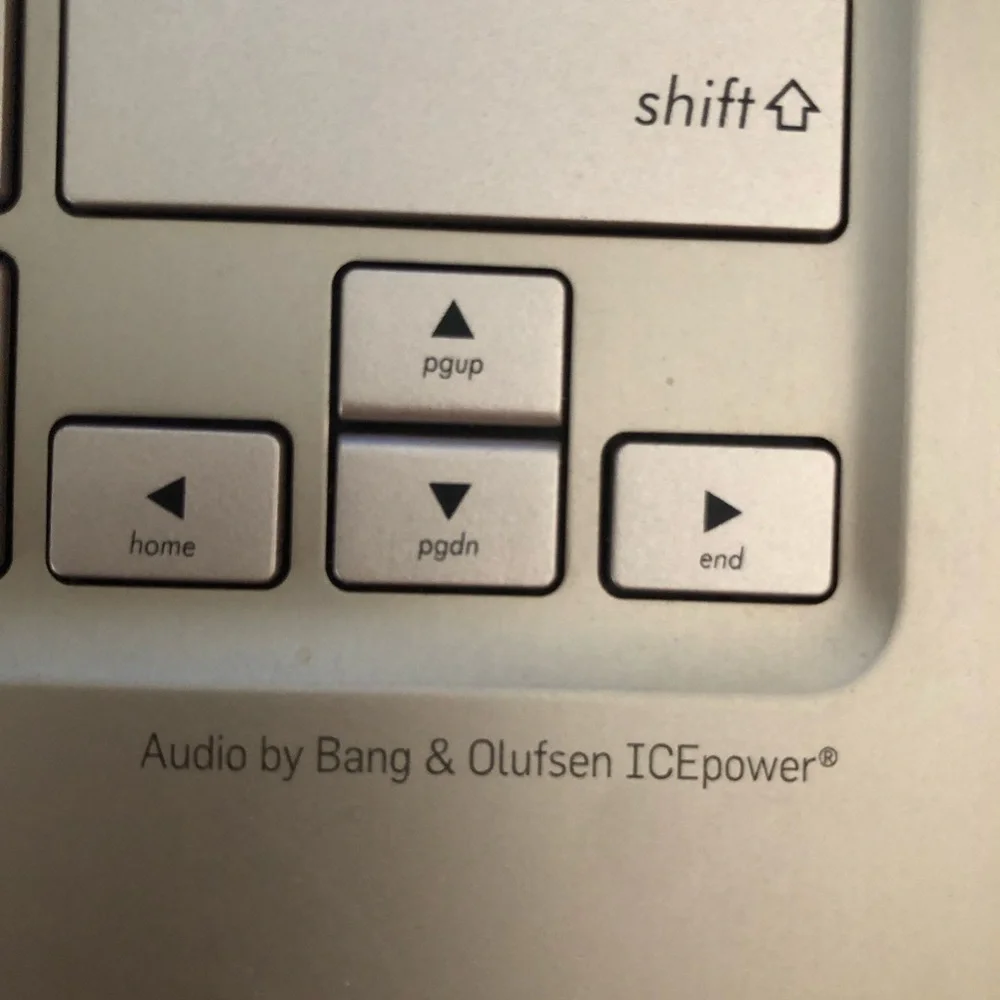 ASUS Metallic Silver Convertible Laptop with a wireless mouse and a charger.